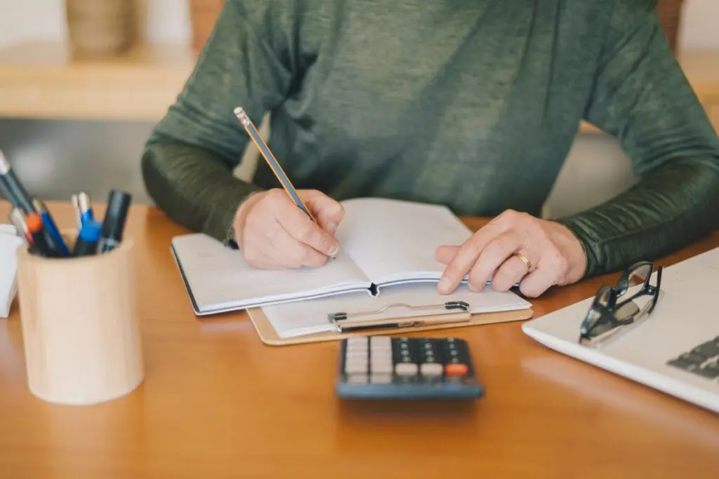 a man with notepad and pencil calculating