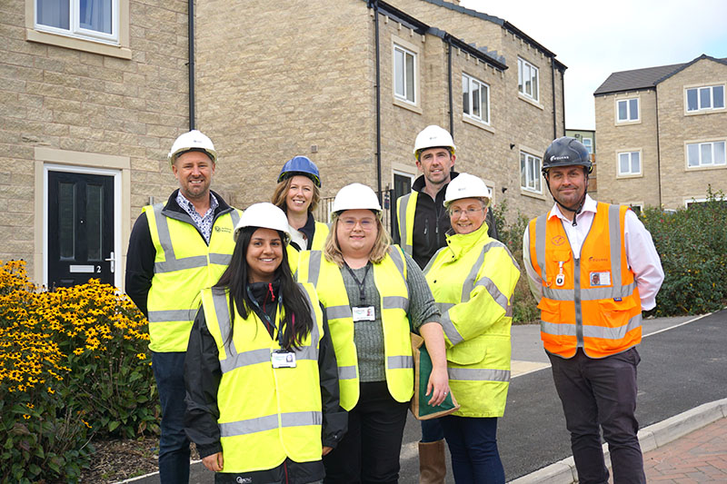 collection of people in building gear in front of houses