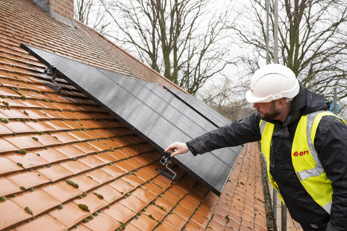 a man on a roof with solar panels